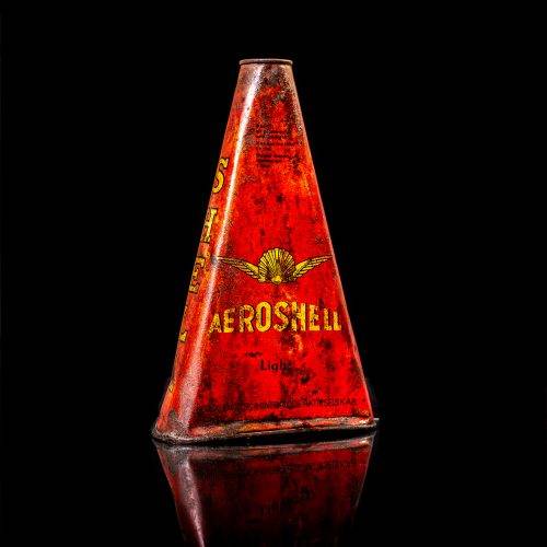Extremely rare and unique vintage Shell triangular oil can from 1900–1950, featuring red and yellow accents and the classic Shell logo, including a rare shell branding. This antique three-sided tin is displayed in a studio setting against a solid black background.