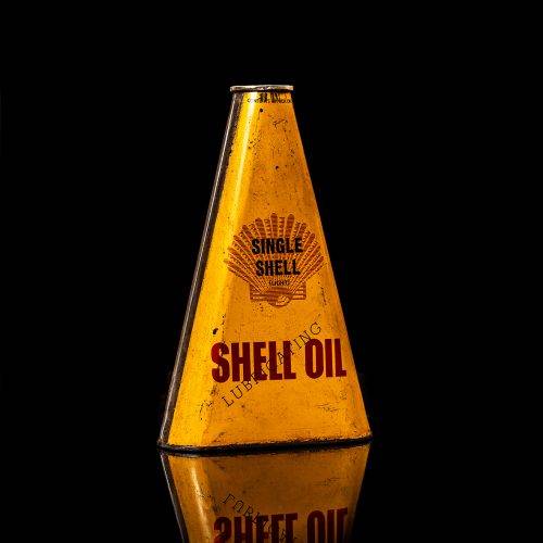 Vintage Shell oil cans with red and yellow branding from the 1900-1920 old logo Vintage Shell oil cans from 1900-19255, featuring the old logo. The photo showcases an antique tin red with yellow accents, displaying the historic Shell emblem. Shot in a studio against a solid black background