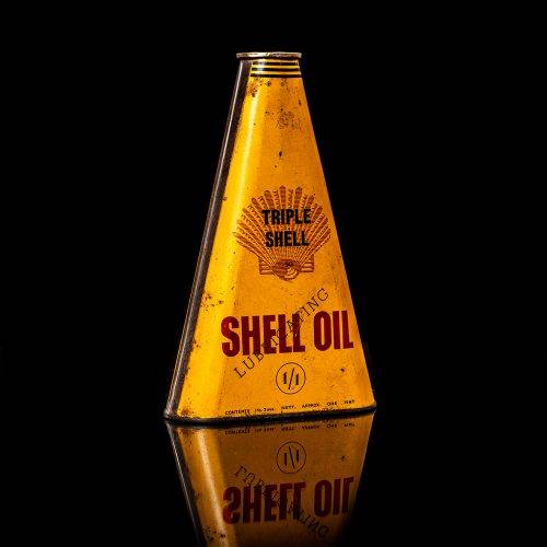 Vintage Shell oil cans with red and yellow branding from the 1900-1920 old logo Vintage Shell oil cans from 1900-19255, featuring the old logo. The photo showcases an antique tin red with yellow accents, displaying the historic Shell emblem. Shot in a studio against a solid black background