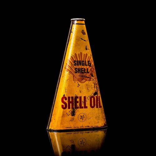 Vintage Shell oil cans with red and yellow branding from the 1900-1920 old logo Vintage Shell oil cans from 1900-19255, featuring the old logo. The photo showcases an antique tin red with yellow accents, displaying the historic Shell emblem. Shot in a studio against a solid black background