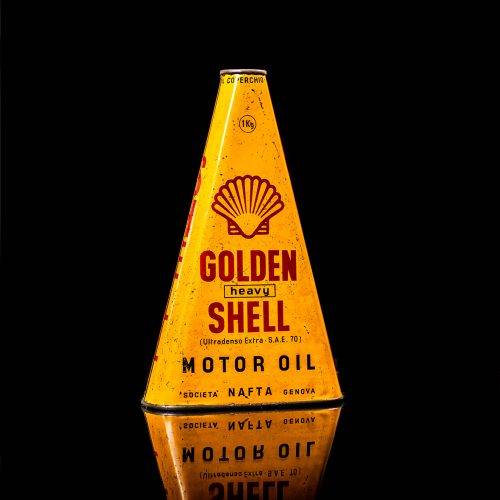 Vintage Shell oil cans with red and yellow branding from the 1900-1920 old logo Vintage Shell oil cans from 1900-19255, featuring the old logo. The photo showcases an antique tin red with yellow accents, displaying the historic Shell emblem. Shot in a studio against a solid black background