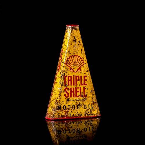 Extremely rare and unique vintage Shell triangular oil can from 1900–1950, featuring red and yellow accents and the classic Shell logo, including a rare shell branding. This antique three-sided tin is displayed in a studio setting against a solid black background.