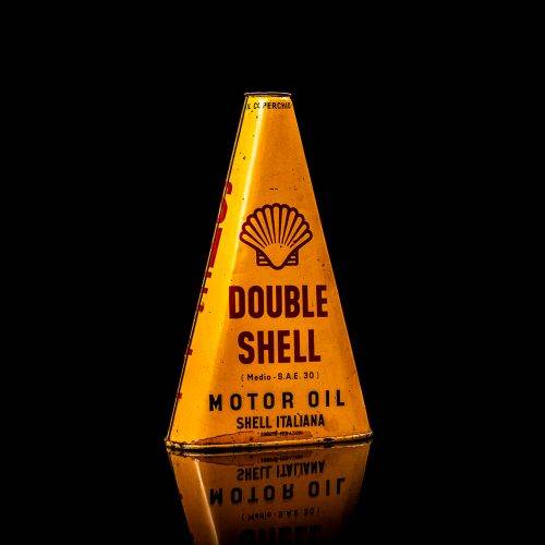 Vintage Shell oil cans with red and yellow branding from the 1900-1920 old logo Vintage Shell oil cans from 1900-19255, featuring the old logo. The photo showcases an antique tin red with yellow accents, displaying the historic Shell emblem. Shot in a studio against a solid black background