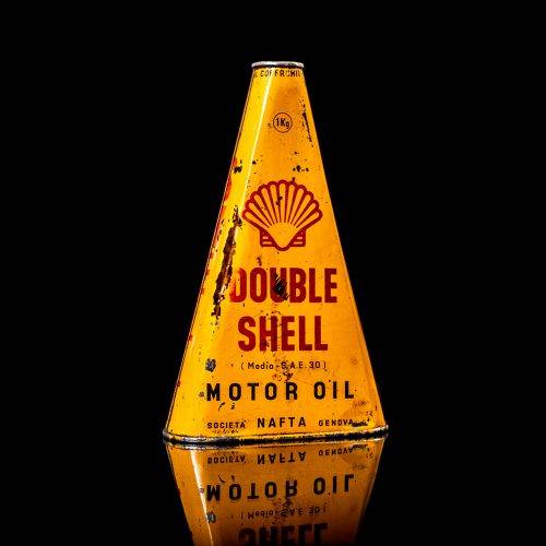 Vintage Shell oil cans with red and yellow branding from the 1900-1920 old logo Vintage Shell oil cans from 1900-19255, featuring the old logo. The photo showcases an antique tin red with yellow accents, displaying the historic Shell emblem. Shot in a studio against a solid black background