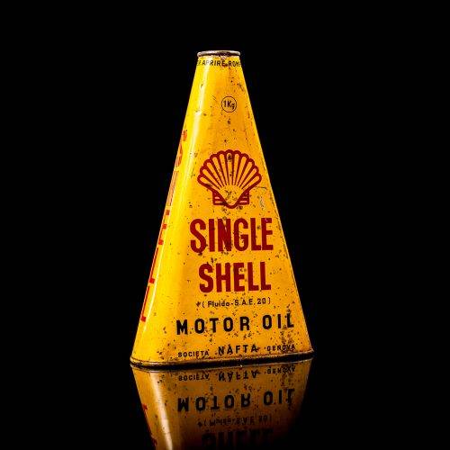 Vintage Shell oil cans with red and yellow branding from the 1900-1920 old logo Vintage Shell oil cans from 1900-19255, featuring the old logo. The photo showcases an antique tin red with yellow accents, displaying the historic Shell emblem. Shot in a studio against a solid black background