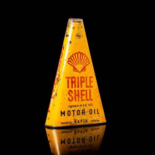 Extremely rare and unique vintage Shell triangular oil can from 1900–1950, featuring red and yellow accents and the classic Shell logo, including a rare shell branding. This antique three-sided tin is displayed in a studio setting against a solid black background.