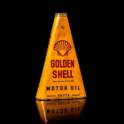 Vintage Shell oil cans with red and yellow branding from the 1900-1920 old logo Vintage Shell oil cans from 1900-19255, featuring the old logo. The photo showcases an antique tin red with yellow accents, displaying the historic Shell emblem. Shot in a studio against a solid black background