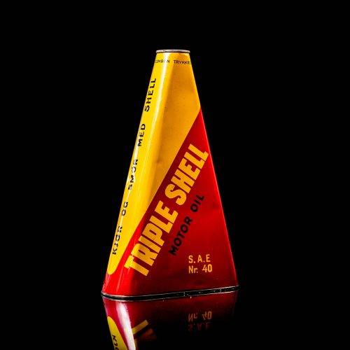 Vintage Shell oil cans with red and yellow branding from the 1900-1920 old logo Vintage Shell oil cans from 1900-19255, featuring the old logo. The photo showcases an antique tin red with yellow accents, displaying the historic Shell emblem. Shot in a studio against a solid black background