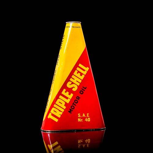 Extremely rare and unique vintage Shell triangular oil can from 1900–1950, featuring red and yellow accents and the classic Shell logo, including a rare shell branding. This antique three-sided tin is displayed in a studio setting against a solid black background.