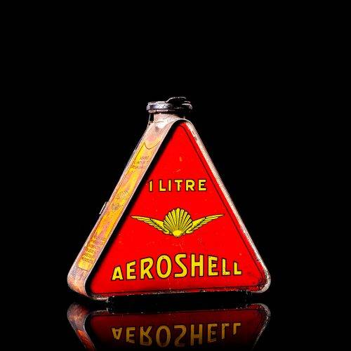 Extremely rare and unique vintage Shell triangular oil can from 1900–1950, featuring red and yellow accents and the classic Shell logo, including a rare shell branding. This antique three-sided tin is displayed in a studio setting against a solid black background.