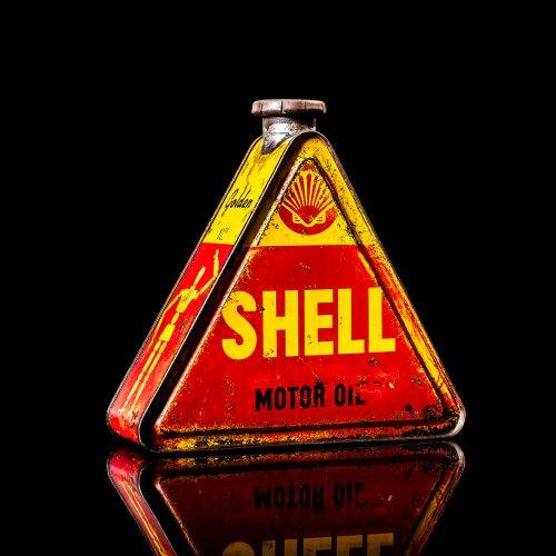 Vintage Shell oil cans with red and yellow branding from the 1900-1920 old logo Vintage Shell oil cans from 1900-19255, featuring the old logo. The photo showcases an antique tin red with yellow accents, displaying the historic Shell emblem. Shot in a studio against a solid black background