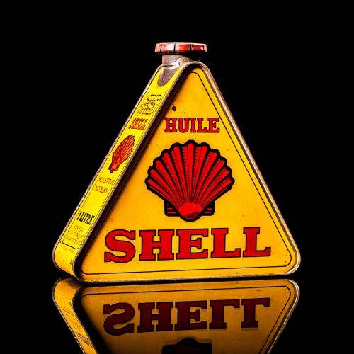 Vintage Shell oil cans with red and yellow branding from the 1900-1920 old logo Vintage Shell oil cans from 1900-19255, featuring the old logo. The photo showcases an antique tin red with yellow accents, displaying the historic Shell emblem. Shot in a studio against a solid black background