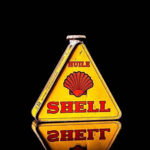 Vintage Shell oil cans with red and yellow branding from the 1900-1920 old logo Vintage Shell oil cans from 1900-19255, featuring the old logo. The photo showcases an antique tin red with yellow accents, displaying the historic Shell emblem. Shot in a studio against a solid black background
