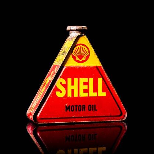 Vintage Shell oil cans with red and yellow branding from the 1900-1920 old logo Vintage Shell oil cans from 1900-19255, featuring the old logo. The photo showcases an antique tin red with yellow accents, displaying the historic Shell emblem. Shot in a studio against a solid black background