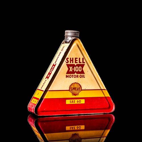 Vintage Shell oil cans with red and yellow branding from the 1900-1920 old logo Vintage Shell oil cans from 1900-19255, featuring the old logo. The photo showcases an antique tin red with yellow accents, displaying the historic Shell emblem. Shot in a studio against a solid black background