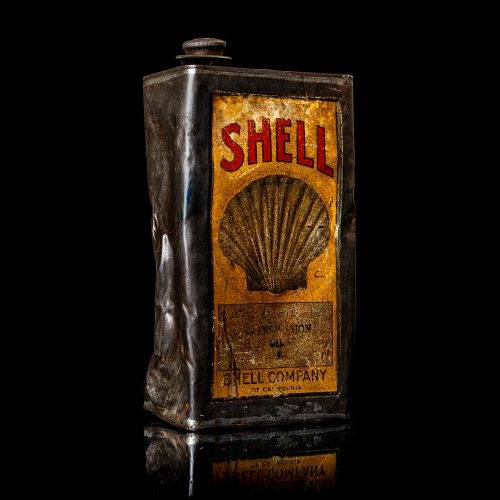Vintage Shell oil cans with red and yellow branding from the 1900-1920 old logo Vintage Shell oil cans from 1900-1920, featuring the old logo. The photo showcases an antique tin red with yellow accents, displaying the historic Shell emblem. Shot in a studio against a solid black background