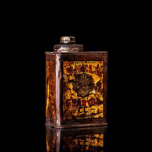 Vintage Shell oil cans with red and yellow branding from the 1900-1920 old logo Vintage Shell oil cans from 1900-1920, featuring the old logo. The photo showcases an antique tin red with yellow accents, displaying the historic Shell emblem. Shot in a studio against a solid black background