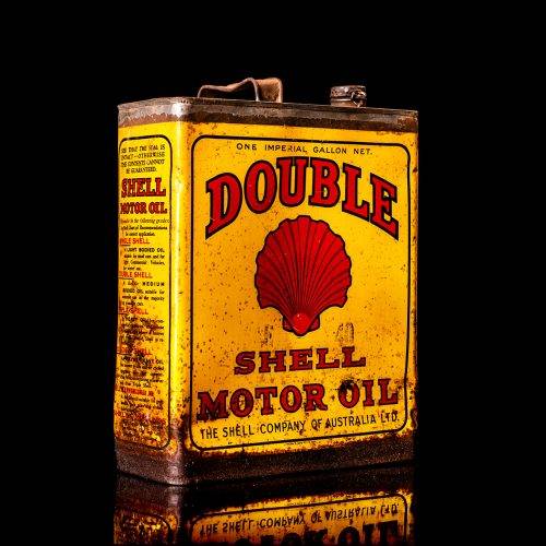 Vintage Shell oil cans with red and yellow branding from the 1920-1940 old logo Vintage Shell oil cans from 1900-1920, featuring the old logo. The photo showcases an antique tin yellow with red accenaccents, displaying the historic Shell emblem. Shot in a studio against a solid black background