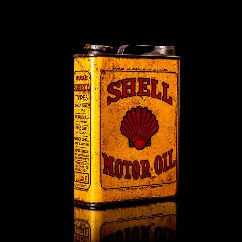 Vintage Shell oil cans with red and yellow branding from the 1920-1940 old logo Vintage Shell oil cans from 1900-1920, featuring the old logo. The photo showcases an antique tin yellow with red accenaccents, displaying the historic Shell emblem. Shot in a studio against a solid black background