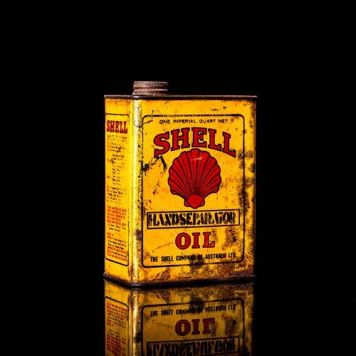 Vintage Shell oil cans with red and yellow branding from the 1920-1940 old logo Vintage Shell oil cans from 1900-1920, featuring the old logo. The photo showcases an antique tin yellow with red accenaccents, displaying the historic Shell emblem. Shot in a studio against a solid black background