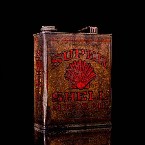 Vintage Shell oil cans with red and yellow branding from the 1920-1940 old logo Vintage Shell oil cans from 1900-1920, featuring the old logo. The photo showcases an antique tin yellow with red accenaccents, displaying the historic Shell emblem. Shot in a studio against a solid black background