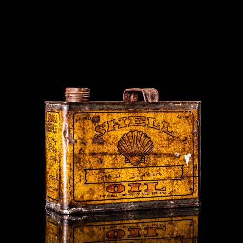 Vintage Shell oil cans with red and yellow branding from the 1920-1940 old logo Vintage Shell oil cans from 1900-1920, featuring the old logo. The photo showcases an antique tin yellow with red accenaccents, displaying the historic Shell emblem. Shot in a studio against a solid black background