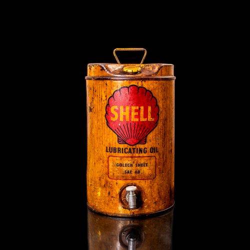 Vintage Shell oil cans with red and yellow branding from the 1920-1940 old logo Vintage Shell oil cans from 1900-1920, featuring the old logo. The photo showcases an antique tin yellow with red accenaccents, displaying the historic Shell emblem. Shot in a studio against a solid black background
