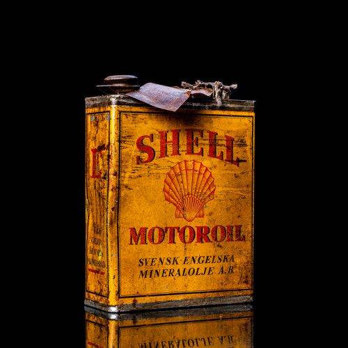Vintage Shell oil cans with red and yellow branding from the 1920-1940 old logo Vintage Shell oil cans from 1900-1920, featuring the old logo. The photo showcases an antique tin yellow with red accenaccents, displaying the historic Shell emblem. Shot in a studio against a solid black background