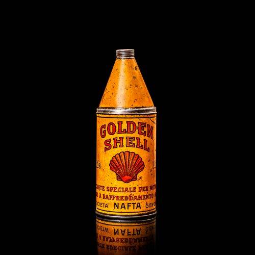 Vintage Shell oil cans with red and yellow branding from the 1920-1940 old logo Vintage Shell oil cans from 1900-1920, featuring the old logo. The photo showcases an antique tin yellow with red accenaccents, displaying the historic Shell emblem. Shot in a studio against a solid black background
