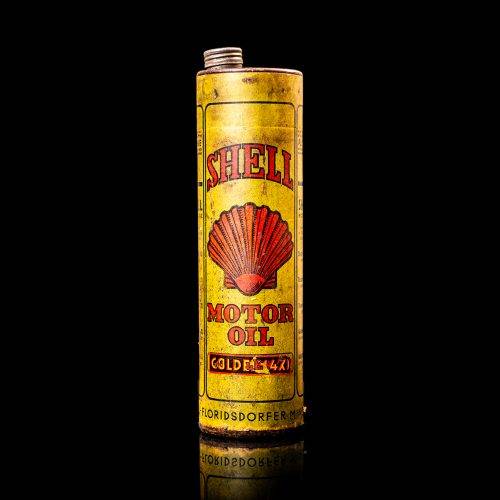 Vintage Shell oil cans with red and yellow branding from the 1920-1940 old logo Vintage Shell oil cans from 1900-1920, featuring the old logo. The photo showcases an antique tin yellow with red accenaccents, displaying the historic Shell emblem. Shot in a studio against a solid black background