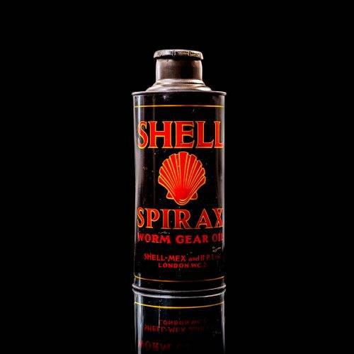 Vintage Shell oil cans with red and yellow branding from the 1920-1940 old logo Vintage Shell oil cans from 1900-1920, featuring the old logo. The photo showcases an antique tin yellow with red accenaccents, displaying the historic Shell emblem. Shot in a studio against a solid black background