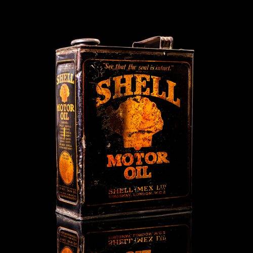 Vintage Shell oil cans with red and yellow branding from the 1920-1940 old logo Vintage Shell oil cans from 1900-1920, featuring the old logo. The photo showcases an antique tin yellow with red accenaccents, displaying the historic Shell emblem. Shot in a studio against a solid black background