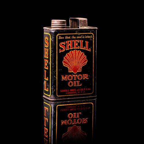 Vintage Shell oil cans with red and yellow branding from the 1920-1940 old logo Vintage Shell oil cans from 1900-1920, featuring the old logo. The photo showcases an antique tin yellow with red accenaccents, displaying the historic Shell emblem. Shot in a studio against a solid black background