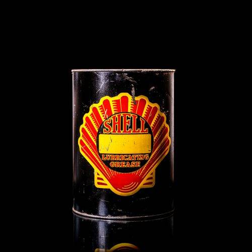 Vintage Shell oil cans with red and yellow branding from the 1920-1940 old logo Vintage Shell oil cans from 1900-1920, featuring the old logo. The photo showcases an antique tin yellow with red accenaccents, displaying the historic Shell emblem. Shot in a studio against a solid black background