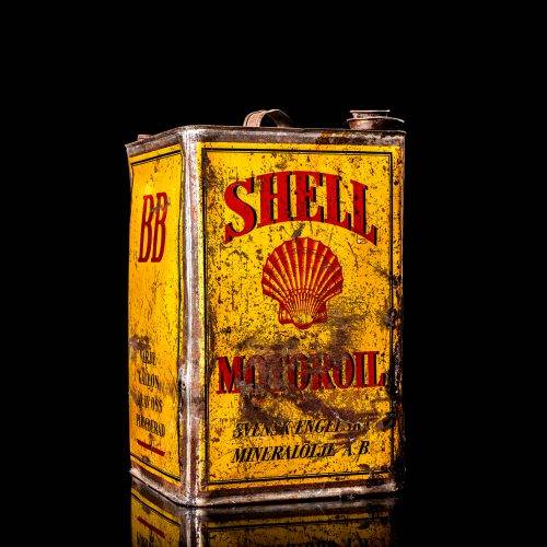Vintage Shell oil cans with red and yellow branding from the 1920-1940 old logo Vintage Shell oil cans from 1900-1920, featuring the old logo. The photo showcases an antique tin yellow with red accenaccents, displaying the historic Shell emblem. Shot in a studio against a solid black background