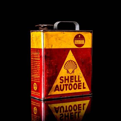 Vintage Shell oil cans with red and yellow branding from the 1920-1940 old logo Vintage Shell oil cans from 1900-1920, featuring the old logo. The photo showcases an antique tin yellow with red accenaccents, displaying the historic Shell emblem. Shot in a studio against a solid black background