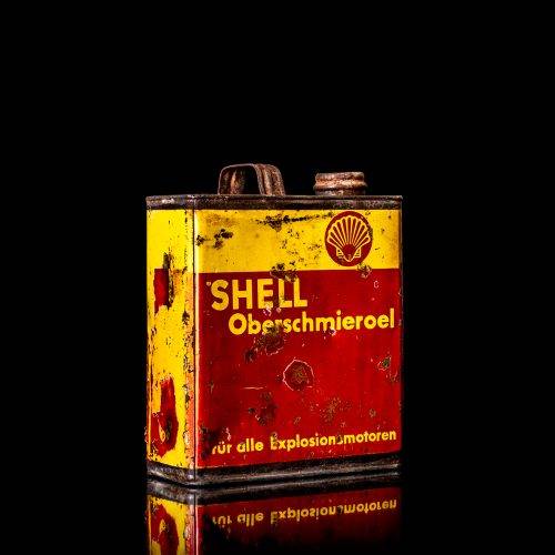Vintage Shell oil cans with red and yellow branding from the 1920-1940 old logo Vintage Shell oil cans from 1900-1920, featuring the old logo. The photo showcases an antique tin yellow with red accenaccents, displaying the historic Shell emblem. Shot in a studio against a solid black background