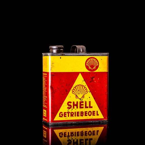 Vintage Shell oil cans with red and yellow branding from the 1920-1940 old logo Vintage Shell oil cans from 1900-1920, featuring the old logo. The photo showcases an antique tin yellow with red accenaccents, displaying the historic Shell emblem. Shot in a studio against a solid black background